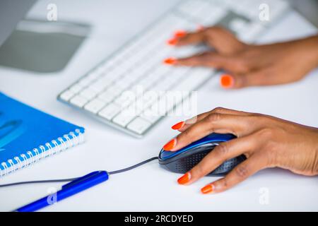Hands fingers on the work computer, laptop, mouse, control pad, details keyboard typing product student classrom study Kenya East African Commercial ad Stock Photo