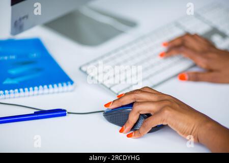 Hands fingers on the work computer, laptop, mouse, control pad, details keyboard typing product student classrom study Kenya East African Commercial ad Stock Photo
