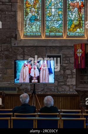 People watching King Charles III coronation on TV screen, St Mary's Parish Church, Haddington, East Lothian, Scotland, UK Stock Photo