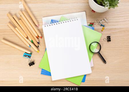 Back to school concept. Top view photo of notepads, pens, sharpeners, ruler, staplers, clips, markers and erasers on wooden table Stock Photo