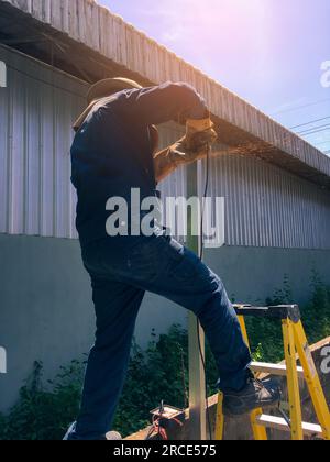 Cutting Metal, Man cutting steel blurred background, Construction concept Stock Photo