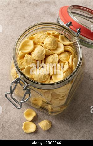 Glass jar with uncooked Orecchiette pasta close up seen from above Stock Photo