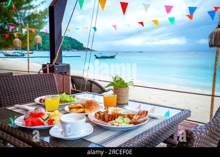Table with breakfast on the beach. Stock Photo