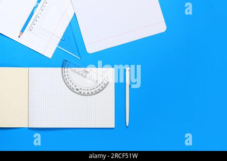 Concept Back to school. Stationery items, notebooks, rulers, pen and pencil on a blue background. Top view of the desk of a schoolboy or student Stock Photo