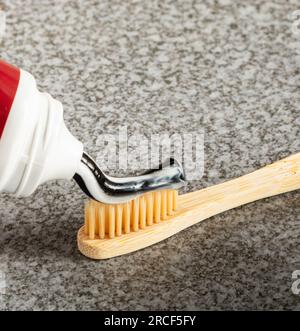 Eco-friendly activated charcoal toothpaste applied to a bamboo toothbrush. Stock Photo