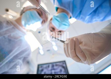 Young surgeon holds a special surgical needle in his hands Stock Photo