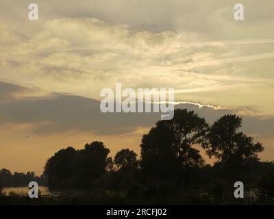 Kew Gardens, Richmond, Surrey, UK - 8th October 2021: View from Syon Outlook at sunset, with contrails and distant plane Stock Photo