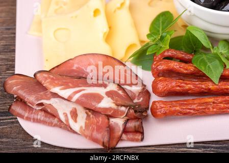 Close-up of cuts of dry-cured pork neck and cheese. Snack plate. Stock Photo