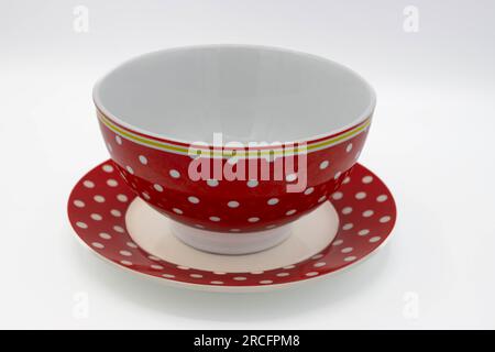 Red polka dot bowl and saucer on white background Stock Photo