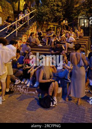Young people socialise on a summers night on some steps in a street in Istanbul, Turkey Stock Photo