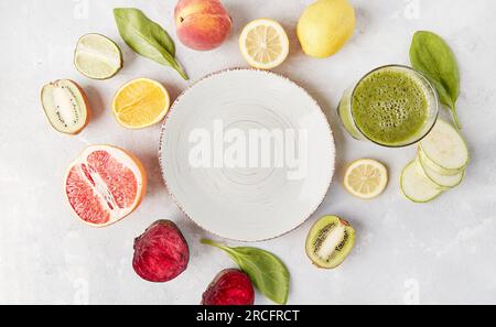 White plate in the center among vegetables, fruits and smoothie. Keto, FODMAP, Paleo, Low-carb diet concept, top view, copy space. Stock Photo