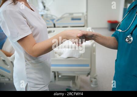 Doctors greeting each other with handshake in hospital Stock Photo