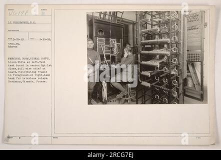 This caption provides factual details about the image: The photograph shows the terminal room of the Signal Corps, with Lieu. White on the left. The toll test board is in the center, operated by Sgt. 1st Class, the toll wire chief. The foreground features distributing frames, and on the right, there is a lamp bank for telephone relays. The location is Bordeaux, Gironde, France. The subject number is 46198, Lt. Strohmeyer, S.C., with the photograph taken on January 11, 1919. Stock Photo