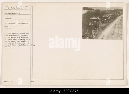 Touring cars on trucks and abandoned German guns in Sedan, Ardennes, France. The Germans stripped these items of their most valuable parts and rendered them useless as they were unable to take them away. Photograph taken on November 17, 1918. Stock Photo