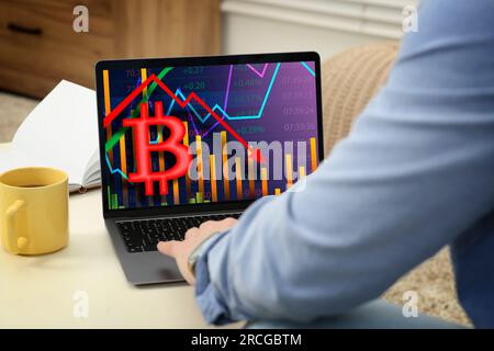 Bitcoin collapse. Trader checking cryptocurrency rates on laptop at home, closeup Stock Photo