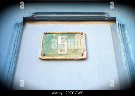 Old door with plate number 5, five, vignette effect. Stock Photo