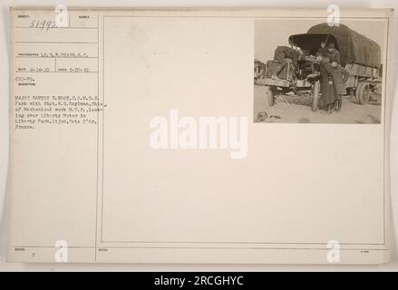 Major Barton B. Root and Capt. W.H. Heylman inspect a Liberty Motor in Liberty Park, Dijon, France. This photograph was taken on January 20, 1919, by Lt. R.H. Sears. The image captures the two officers examining the motor as part of their duties in overseeing mechanical work in the Motor Transport Corps. Stock Photo