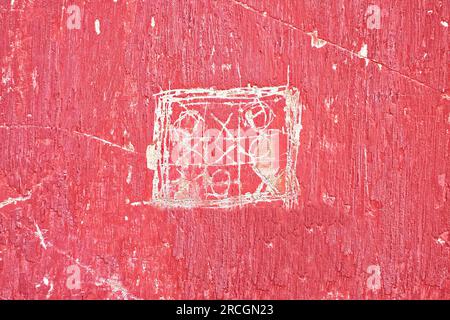 Tic tac toe or noughts and crosses game scratched on a red wall. Stock Photo