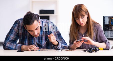 The two technicians working at computer warranty center Stock Photo