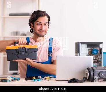 The young male contractor repairing computer Stock Photo