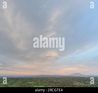 Soft pink color sunset sky background over volcano  green landscape Stock Photo