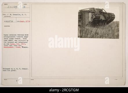 'Pvt. J.W. Crunelle of the S.C. is seen in this photograph capturing tanks crushing through wire entanglements towards an imaginary enemy trench. Tank #2559, shown here, was captured by the Germans and later recaptured at the Somme by the 107th Infantry Division of the 27th Division. This photo was taken in Beauquesnes, Somme, France. It was released by the A.E.F. Censor, although the specific date of release is unknown.' Stock Photo