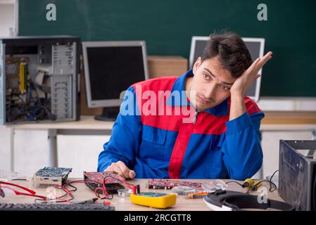 Young repairman repairing computers in the classroom Stock Photo