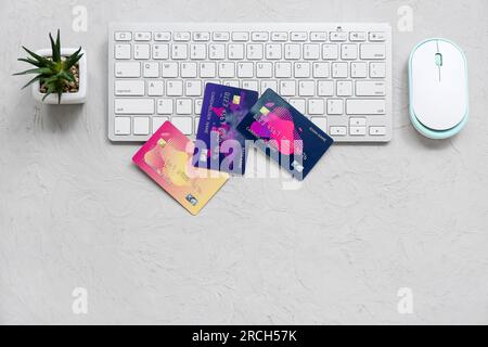 Keyboard with different credit cards and computer mouse on grunge grey background Stock Photo