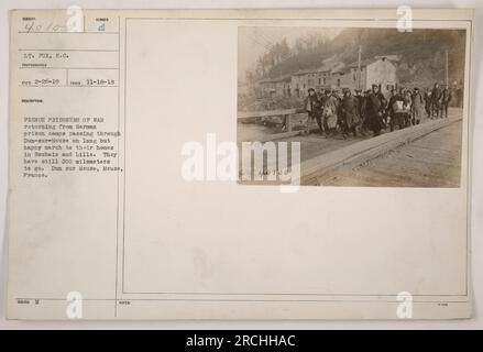 French Prisoners of War returning from German prison camps pass through Dun-sur-Meuse on a long march home to Roubaix and Lille. They still have 200 kilometers to go. The photograph was taken by Lt. Fox on November 18, 1918. Location: Dun sur Meuse, Meuse, France. Reference number: 111-SC-40100. Stock Photo