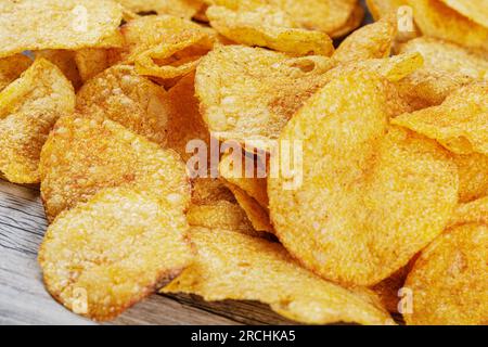 Delicious Barbeque Flavored Potato Chips isolated on a wooden background with copy space Stock Photo