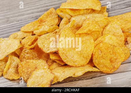 Delicious Barbeque Flavored Potato Chips isolated on a wooden background with copy space Stock Photo