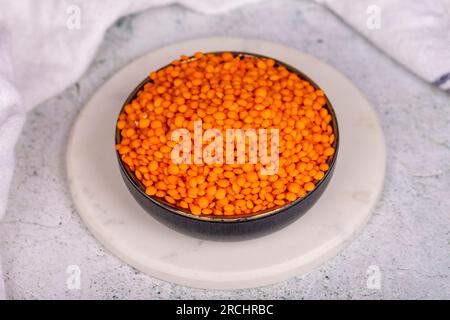 Red lentils on grey background. Raw red lentils in bowl Stock Photo
