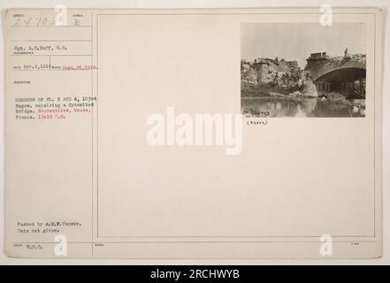 Sgt. A. C. Duff, S.C, is seen in this photograph taken on September 26, 1918. The image shows members of Co. E and A, 103rd Engrs. repairing a dynamited bridge in Boureuilles, Meuse, France. The photograph was taken at 12:15 P.M. and passed by A.E.P. Censor. The date of issuance is not given. Stock Photo