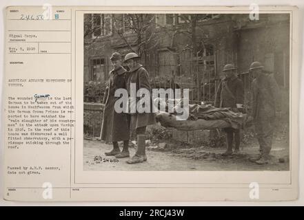 Caption: 'Soldiers carrying the wounded German soldier out of a house in Montfaucon, a location in the American advance northwest of Verdun during World War One. This house is reputed to be where the German Crown Prince observed the attack on Verdun in 1916. The house had a well-equipped observatory and a periscope. Photograph taken on November 5, 1918.' Stock Photo