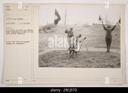A group of military personnel from the S.C. School of Radio and Multiplex Telegraphy at the College of the City of New York conducting field work. They are seen using the heliograph, wig-wag, and semaphore methods of communication. This photo was taken in December 1918. Stock Photo