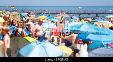 15 July 2023, Schleswig-Holstein, Grömitz: Holidaymakers enjoy the summer on the Baltic Sea beach in Grömitz. Photo: Markus Scholz/dpa Stock Photo