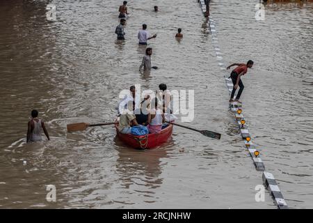 New Delhi, India. 14th July, 2023. People row their boat on a flooded road after a rise in the water level of the river Yamuna following heavy monsoon rains in New Delhi. The government issued warnings of flood-like conditions and asked people living in the riverbed or low-lying areas to evacuate their homes. Credit: SOPA Images Limited/Alamy Live News Stock Photo