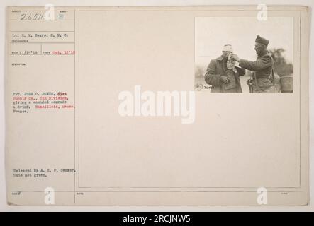 Private John C. Jones of the 6th Supply Company in the 5th Division, providing a wounded soldier with a drink in Nantillois, Meuse, France. This photograph was taken on October 12, 1918, by Lieutenant R. W. Sears of the Signal Corps. It was released by the A. E. F. Censor, but the exact date of release is unknown. Stock Photo