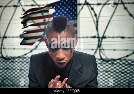 african american rapper with the american flag and barbed wire in the background Stock Photo