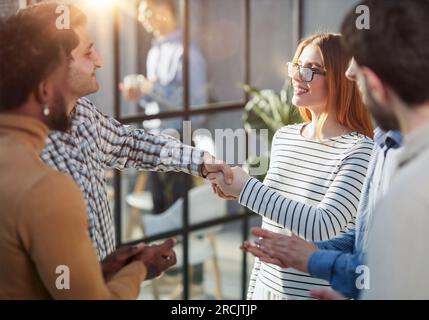 Multiethnic business people shaking hands in office lobby Stock Photo
