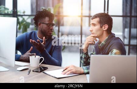 Business people working together in a modern trendy office behind a laptop Stock Photo