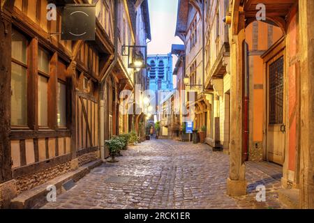 Night scene along the historicy Ruelle des Chats in the old town of Troyes, Aube department, France. The tower of St. Madeleine Church is overlooking Stock Photo