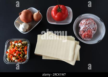 Uncooked lasagna ingredients, designed on black background Stock Photo