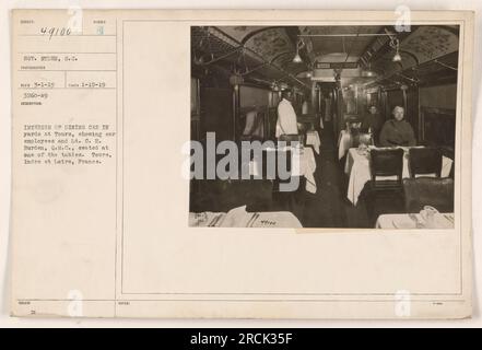 Interior of a dining car at Tours, France during World War I. The photograph shows car employees and Lt. C.H. Burden, Q.M.C., seated at one of the tables. Sergeant Hyden, S.C., is also in the photo. The image was captured on January 15, 1919 by photographer Reco and issued under the number 49100. Stock Photo