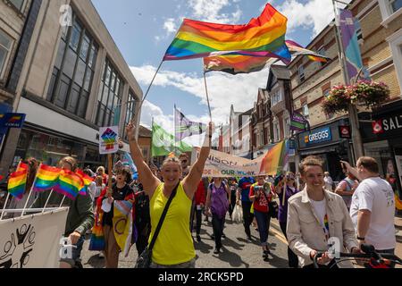 Southend on Sea, UK. 15th July, 2023. Colourful and energetic Southend Pride parade on the High Street, featuring rainbow flags, UNISON banners, and joyful participants advocating for LGBTQ+ rights. Commercial storefronts and hanging flower baskets frame the festive civic atmosphere. Thousands of people take part in the annual Pride Parade on the High Street and festival in Warrior Square. Penelope Barritt/Alamy Live News Stock Photo