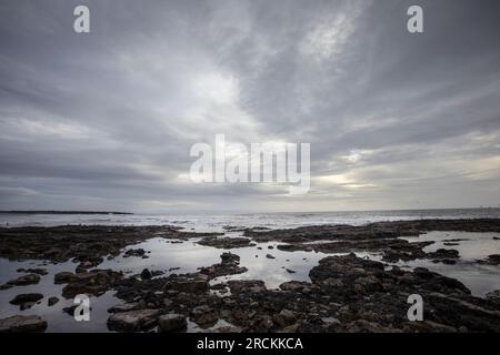 Rocky shore with clouds, Kenfig beach, Wales, UK Stock Photo
