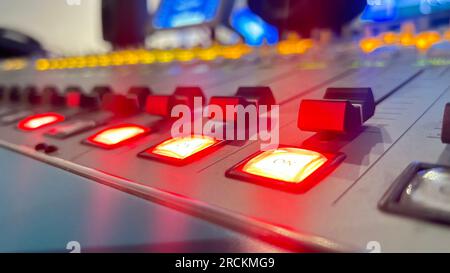 Close up of a control panel of a sound recording studio with red light. Stock Photo