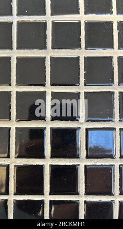 Detail of a ceramic tile wall with black and white mosaic tiles Stock Photo