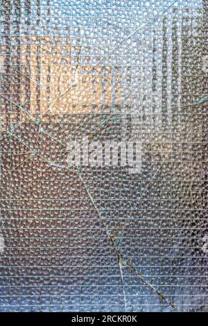 Window damage with lines of cracks on glass surface. Broken glass texture. Stock Photo