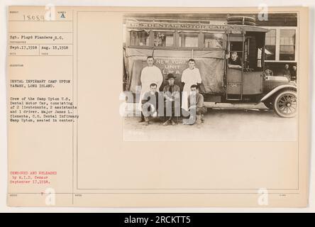 Sgt. Floyd Flanders and the crew of the Camp Upton U.S. Dental Motor Car are seen in this photograph taken on August 15, 1918. The dental infirmary in Camp Upton, located in Yaphank, Long Island, is depicted in the image. Major James L. Clements, who was the Commanding Officer of the Dental Infirmary, is seated in the center. The photograph was taken by a photographer and received on September 17, 1918. It was later censored and released by M.I.D. Censor for public distribution. The image shows the U.S. Dental Motor Car, designated as N93, which belonged to the New York Unit of the Line of the Stock Photo